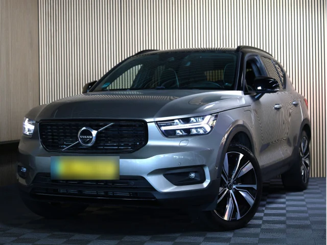 Grijze Volvo XC40 in de fotohoek van AVM met houten latwand en geblokte vloer