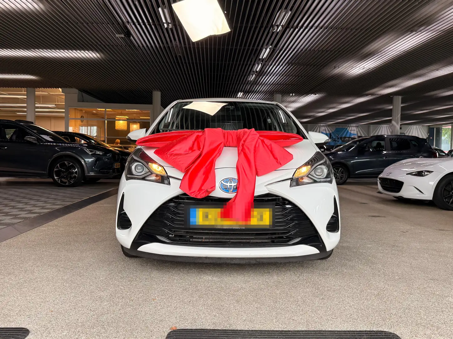 Auto met rode strik klaar voor aflevering aan de nieuwe eigenaar via AVM Auto Verkoop Makelaar