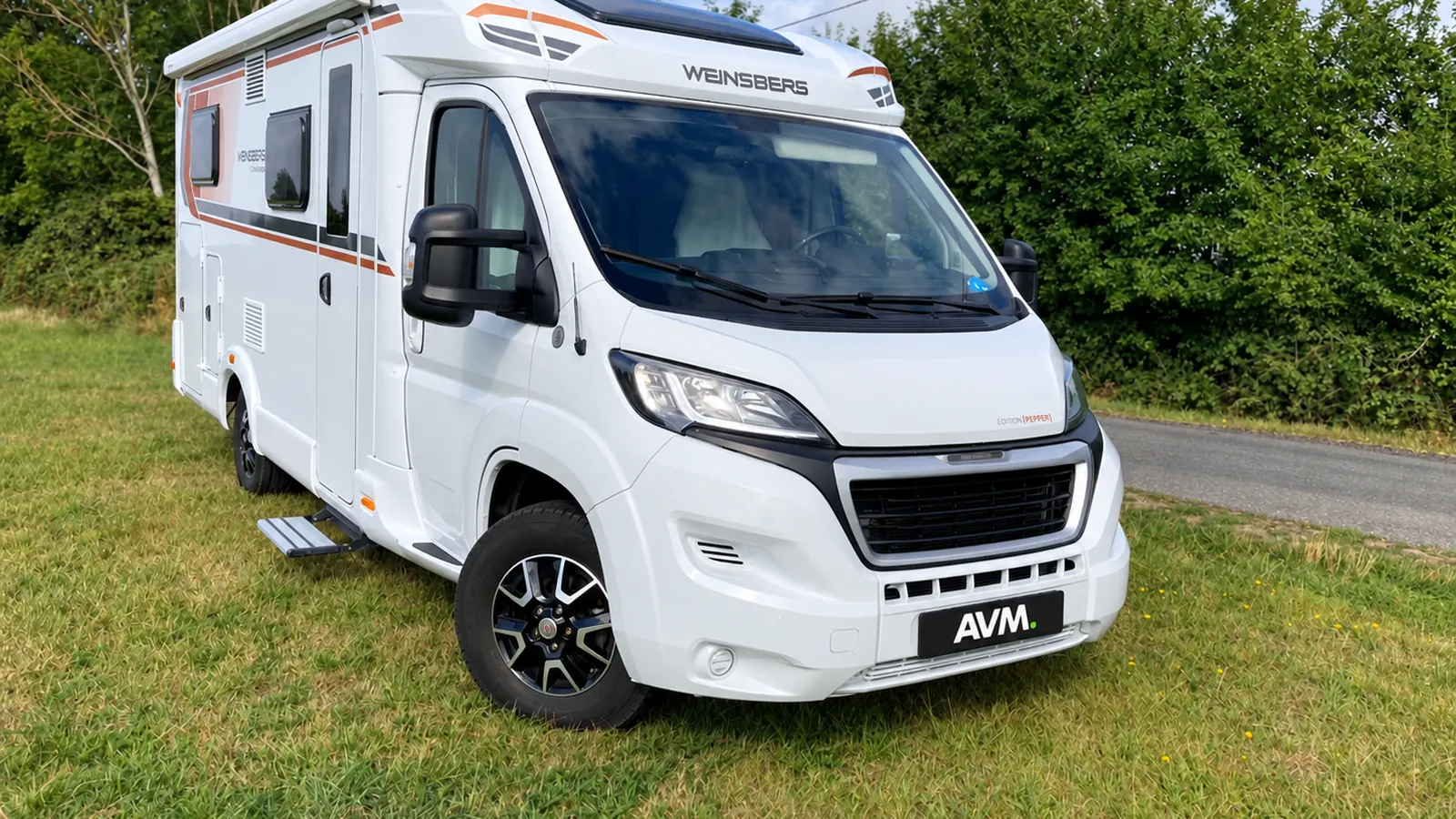 Weinsberg-camper met AVM-kentekenplaat professioneel gefotografeerd op het gras