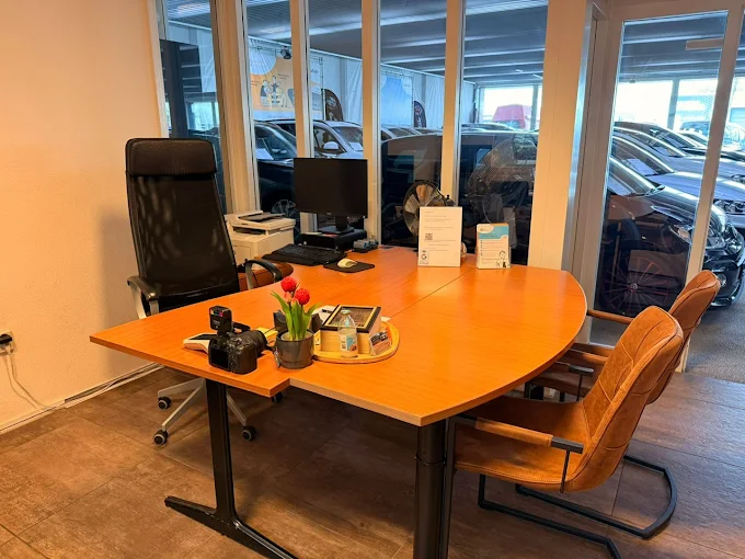 Kantoor van AVM Auto Verkoop Makelaar met vergadertafel en zicht op de showroom