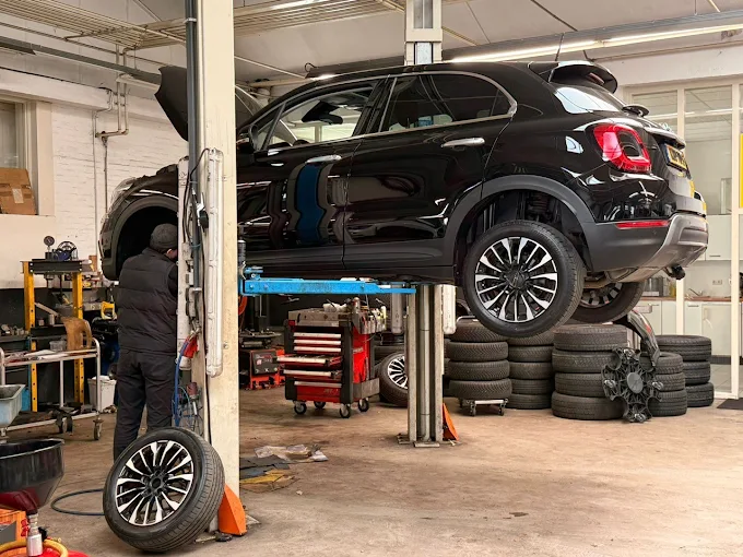 Auto op de brug in de werkplaats bij AVM